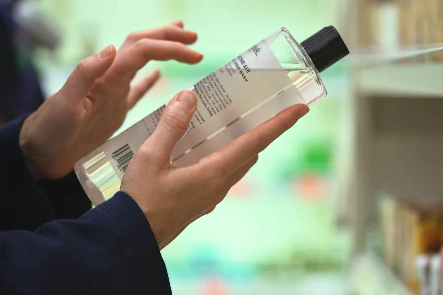lady reading label on skin care in cosmetics store